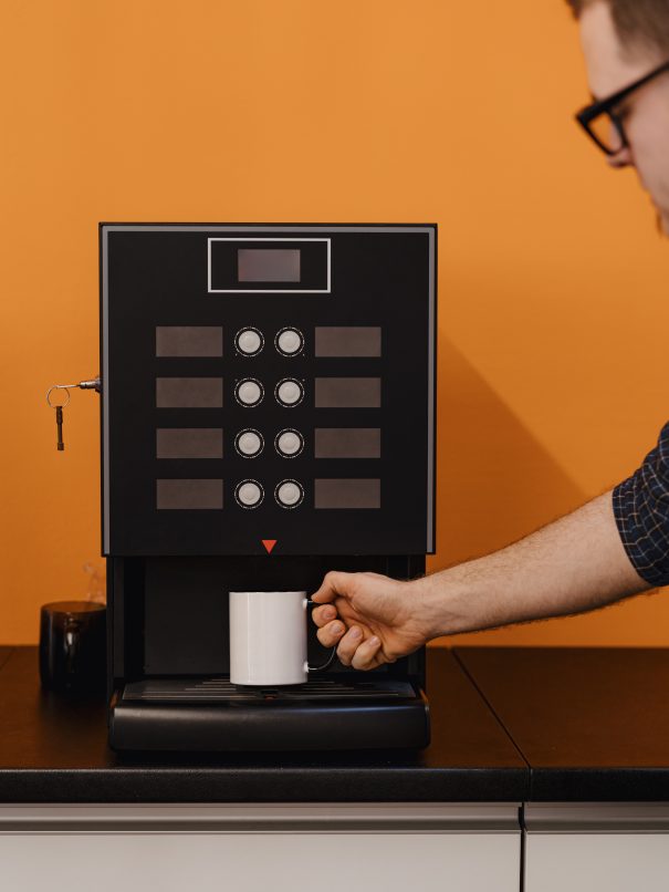 man holding mug near coffee machine malaysia